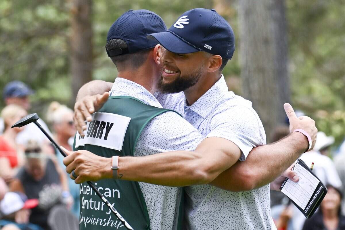 Golden State Warriors guard Stephen Curry embraces his caddy during the American Century Golf Tournament in Stateline, Nev. on Sunday.