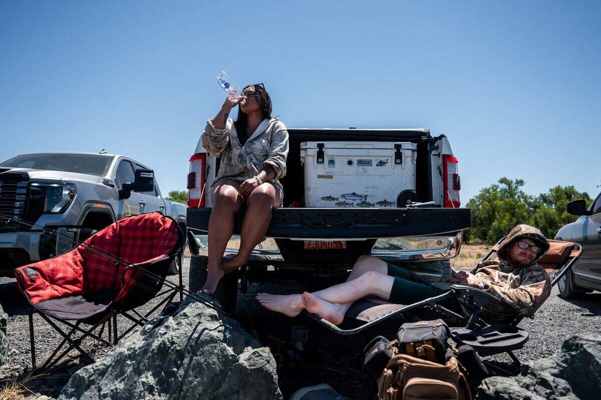 Sarah Post, left, and Chandler Clarke, from Utah, take a break during the opening day of the salmon fishing season in Thermalito Afterbay Outlet in Oroville Wildlife Area in Oroville on Thursday, July 16, 2026.
