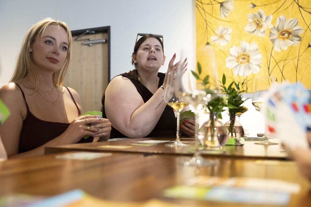 Julia Dejardin, left, and Shelby Brendle play the Monopoly Deal card game, as Girls’ Night Out Sacramento gathers at Alma Wine Bar in Sacramento on Tuesday July 28, 2026.