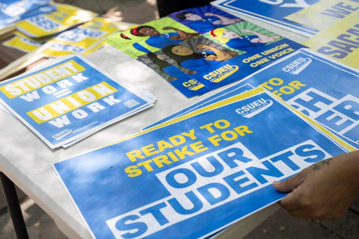 Members of the California State University Employees Union grab signs as they picket at Sacramento State on Tuesday, June 30, 2026 — the day their contracts expire. The series of systemwide union actions come as negotiations for a fresh contract are ongoing. Union members are asking for better pay and reduced dependence on temporary workers.