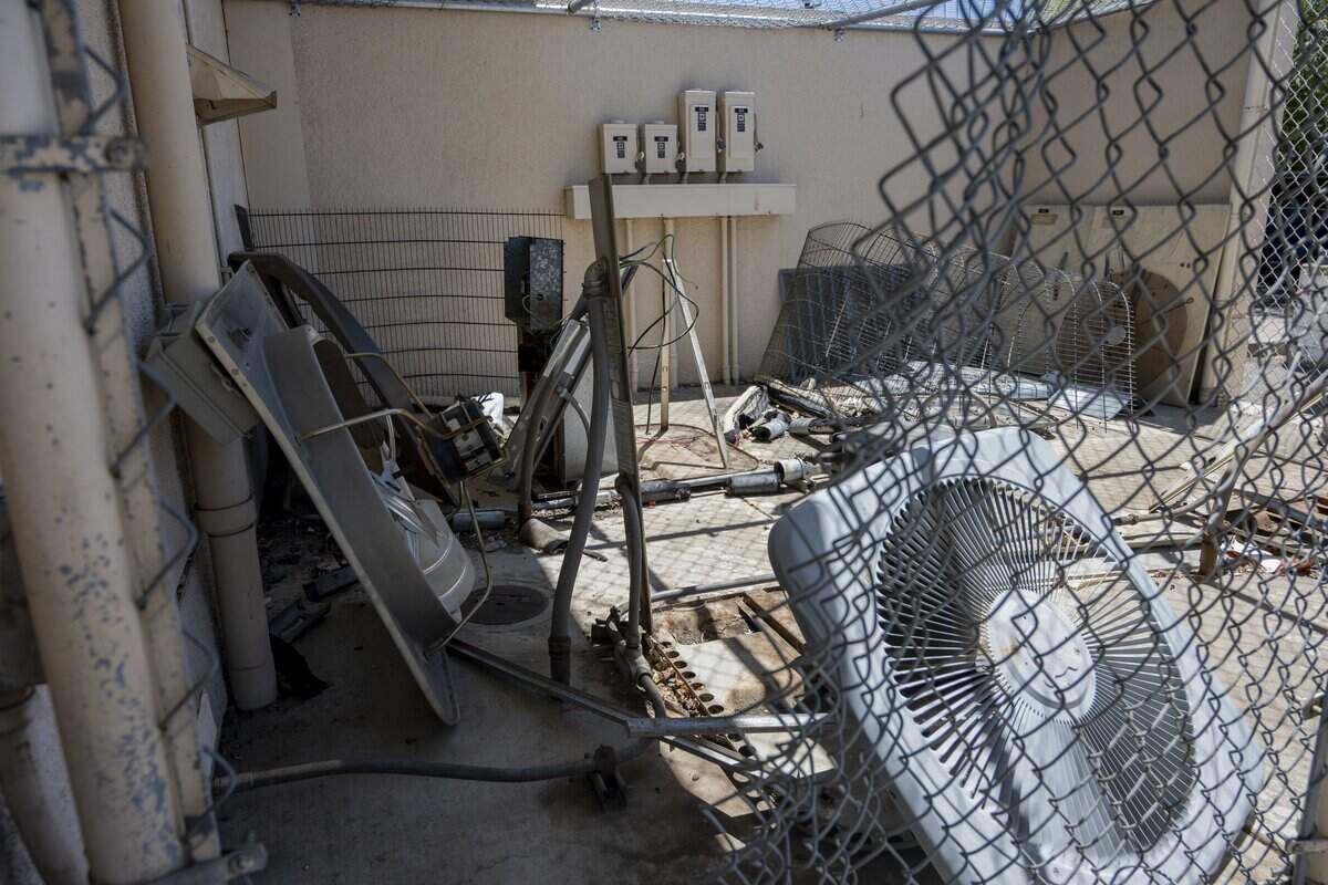 A hole cut in the fence and remaining pieces of a dismembered air conditioning unit sit behind the Centre Branch Post Office in Arden Arcade on Thursday, July 16, 2026. The post office has been a target of copper wire theft three times since Memorial Day, according to the Sacramento Postmasters Office.