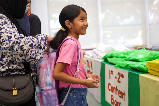 Korina, 7, of San Jose smiles while trying on a backpack at Sacred Heart Community Service in San Jose, Calif., on Tuesday, July 28, 2026. (Shae Hammond/Bay Area News Group)
