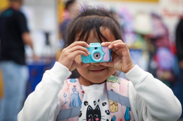 Yesica Ventura, 4, of San Jose plays with a toy camera after picking out a backpack at Sacred Heart Community Service in San Jose, Calif., on Tuesday, July 28, 2026. (Shae Hammond/Bay Area News Group)