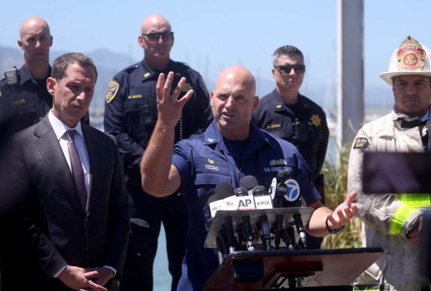 U.S. Coast Guard Capt. Jarod Toczko speaks to the media during a press conference at Fort Mason in San Francisco, Calif., on Wednesday, July 15, 2026. To the left is San Francisco Mayor Daniel Lurie. One person died and three are missing after a boat capsized near Alcatraz Island yesterday while on the water for a memorial service. (Jane Tyska/Bay Area News Group)