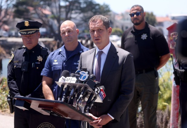 San Francisco Mayor Daniel Lurie speaks to the media during a press conference at Fort Mason in San Francisco, Calif., on Wednesday, July 15, 2026. To the left is U.S. Coast Guard Capt. Jarod Toczko. One person died and three are missing after a boat capsized near Alcatraz Island yesterday while on the water for a memorial service. (Jane Tyska/Bay Area News Group)