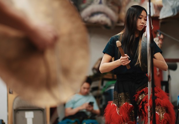 Sun Hing member Alicia Trinh beats a gong to accompany the lion dance, Friday, April 17, 2026 in San Jose, Calif.(Photo by Yu Wang)