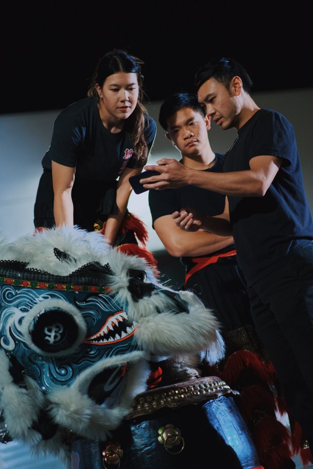 The Sun Hing competition partners, Isabelle André, left, Bryan Huynh, center, and team leader Kevin Nguyen, right, record themselves practicing their routine for the competition and review the footage together to identify and correct mistakes, Friday, April 17, 2026, in San Jose, Calif. (Photo by Yu Wang)