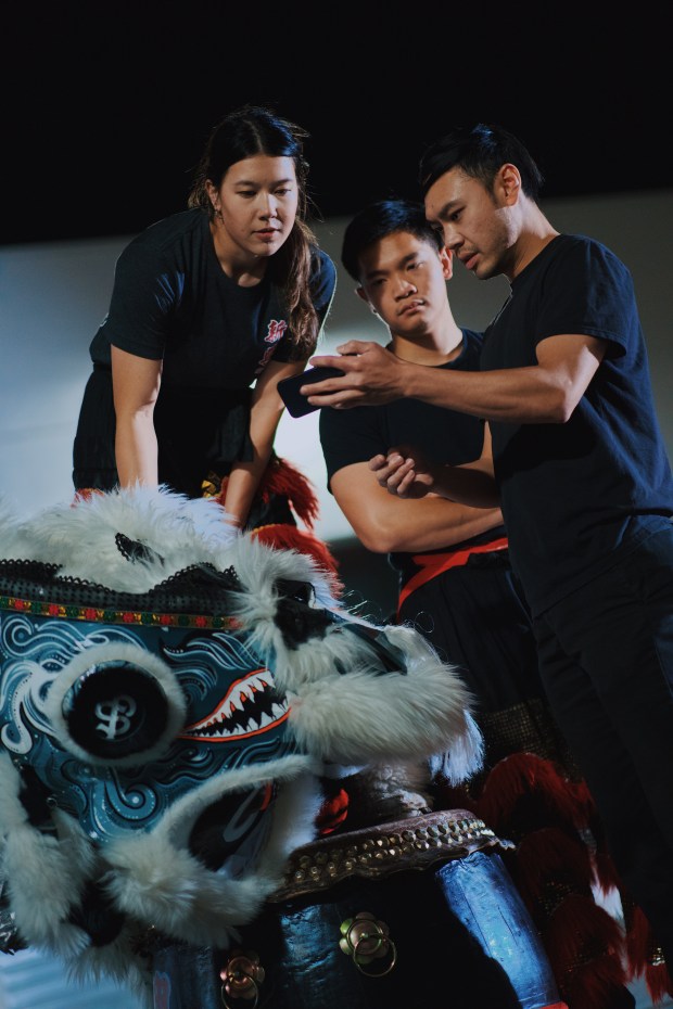 The Sun Hing competition partners, Isabelle André, left, Bryan Huynh, center, and team leader Kevin Nguyen, right, record themselves practicing their routine for the competition and review the footage together to identify and correct mistakes, Friday, April 17, 2026, in San Jose, Calif. (Photo by Yu Wang)