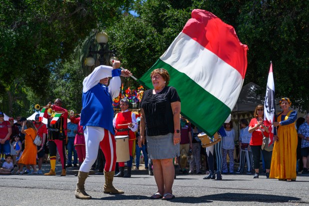 Ivan Samori, director of Sbandieratori e Musici Faentini del Palio del Niballo, twirls a flag past brave volunteer Karen Vanderpan, of Los Gatos, during the 44th annual Italian Family Festa held at History Park in San Jose, Calif., on Saturday, July 25, 2026. The event is hosted by the Italian American Heritage Foundation. (Jose Carlos Fajardo/Bay Area News Group)