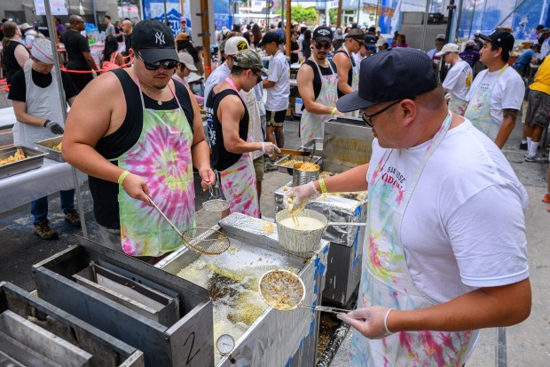 Alex Tsukahara, left, and Brett Low work the hot oil machine while making tempura during the San Jose Obon Festival in San Jose, Calif., on Saturday, July 11, 2026. (Jose Carlos Fajardo/Bay Area News Group)