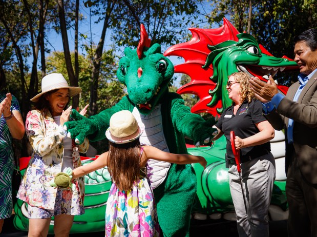 Santa Clara County Supervisor Betty Duong, center left, celebrates cutting the ribbon with her daughter Harper Duong, 8, and San Jose Councilmember Bien Doan, right, for the reopening of the Danny the Dragon ride at Happy Hollow Park & Zoo in San Jose, Calif., on Tuesday, July 15, 2025. (Shae Hammond/Bay Area News Group)