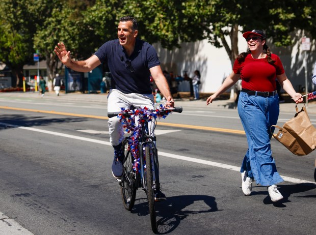 United States Representative Sam Liccardo waves at people as he rides a bike during the RW&B Parade along The Alameda in San Jose, Calif., on Saturday, July 4, 2026. (Shae Hammond/Bay Area News Group)