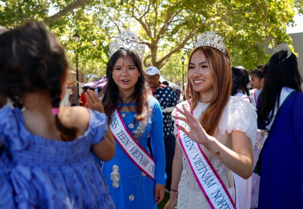 Samantha Tran, 17, of San Jose, left, and Tiffany Nighe, 20, of San Jose, right, with Miss Vietnam USA, wave at a child during the RW&B Parade along The Alameda in San Jose, Calif., on Saturday, July 4, 2026. (Shae Hammond/Bay Area News Group)