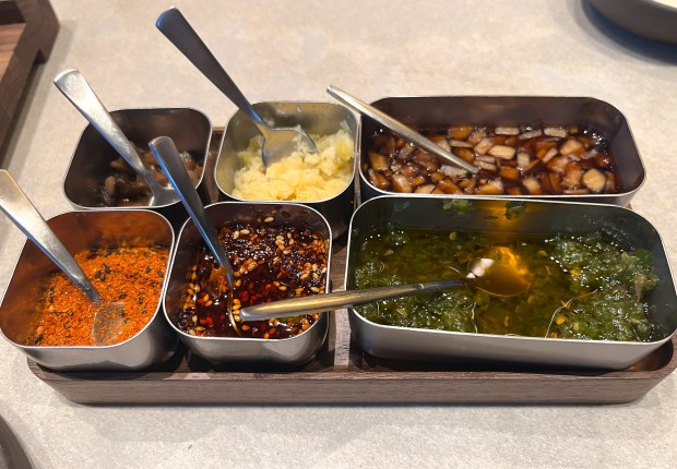 The restaurant Twinflame opened in July 2026 serving Japanese-style hamburger steak with rice and egg and various condiments in Oakland, Calif. Pictured: dried-bonito tamari, marinated shiitake mushrooms, green chiles in olive oil and other toppings. (John Metcalfe/Bay Area News Group)