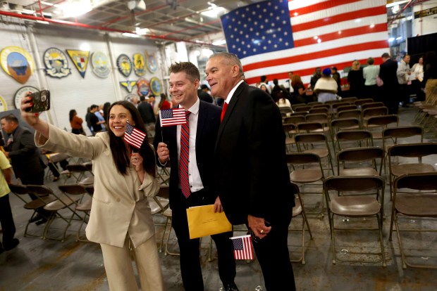 New citizen Sebastian Belz, center, poses for a photo with Alyssa Belz, left, and John Daley, right, after a naturalization ceremony aboard the USS Hornet Sea, Air & Space Museum on Wednesday, July 1, 2026, in Alameda, Calif. A total of 76 community members from 28 different countries became new American citizens during the ceremony. (Aric Crabb/Bay Area News Group)
