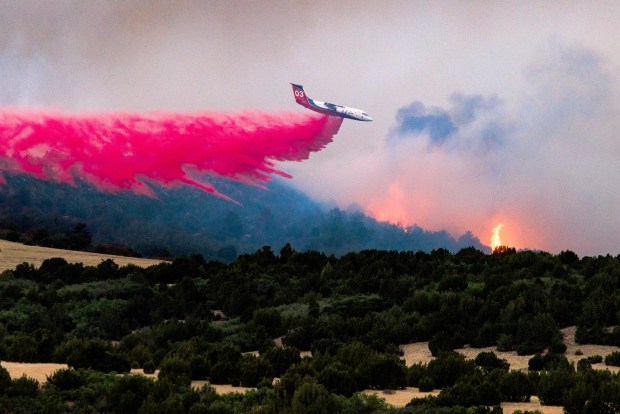 A firefighting plane drops fire retardant over the Aspen Acres fire on July 1, 2026 in Colorado City, Colorado. Over 35,000 acres and more than 100 structures have burned in the Aspen Acres fire, one of several blazes that are currently burning across the state after a warm and dry winter. (Photo by Michael Ciaglo/Getty Images)