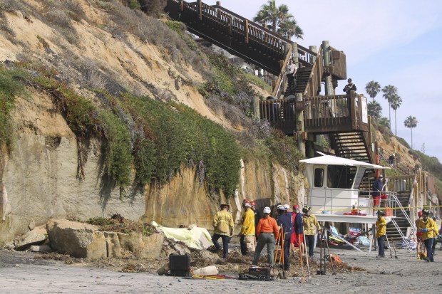 Emergency personnel work at a section of oceanfront bluff that collapsed killing one woman and injuring three just north of the Grandview beach access stairway in Leucadia on Friday, August 2, 2019 in Encinitas, California.  (Hayne Palmour IV / The San Diego Union-Tribune)