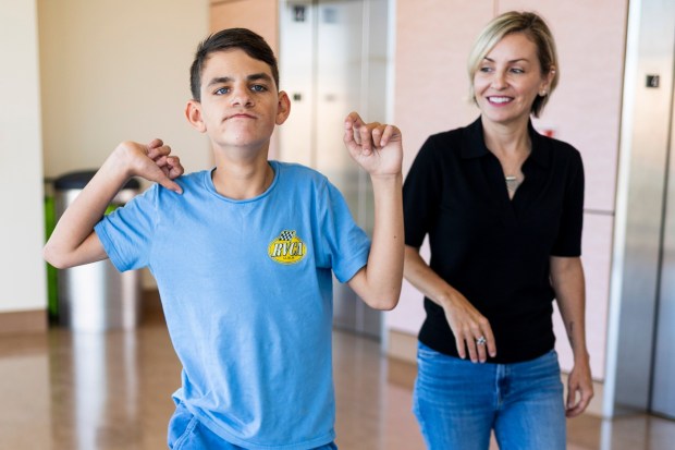 Connor Dalby, 17, and his mom Kelley Del Real take a walk together in the hallway at Rady Children's Hospital on Wednesday, July 22, 2026 in San Diego, California. (Meg McLaughlin / The San Diego Union-Tribune)