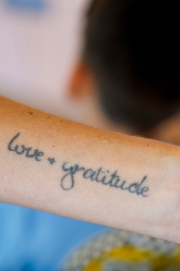Kelley Del Real shows off her tattoo as she wheels her son to the elevator at Rady Children's Hospital on Wednesday, July 22, 2026 in San Diego, California. (Meg McLaughlin / The San Diego Union-Tribune)