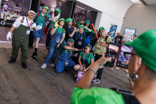 San Diego, California - Attendees cosplaying as Luigi from the video game Super Mario Bros. pose for photos during Comic-Con on Saturday, July 25, 2026. (Kristian Carreon / The San Diego Union-Tribune)