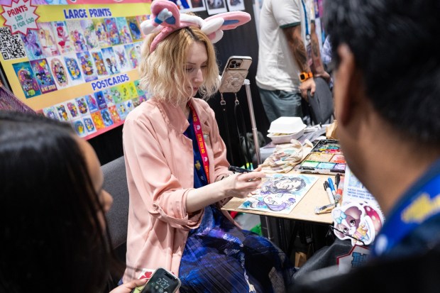 San Diego, CA - Agnes Garbowska signs prints in the main exhibit hall during Comic-Con on Saturday, July 25, 2026, in San Diego, CA. (Luke Johnson / The San Diego Union-Tribune)