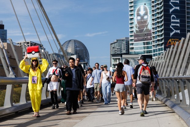 San Diego, California - People cross the bridge over Harbor Drive, near the convention center, during Comic-Con on Saturday, July 25, 2026. (Kristian Carreon / The San Diego Union-Tribune)