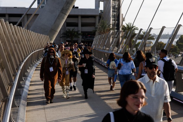 San Diego, California - Attendees walk on the bridge over Harbor Drive near the convention center during Comic-Con on Saturday, July 25, 2026. (Kristian Carreon / The San Diego Union-Tribune)