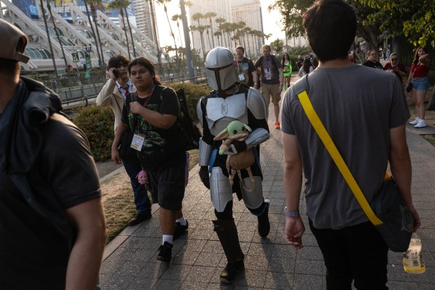 San Diego, CA - People walk along the trolley tracks towards the Gaslamp during Comic-Con on Saturday, July 25, 2026, in San Diego, CA. (Luke Johnson / The San Diego Union-Tribune)