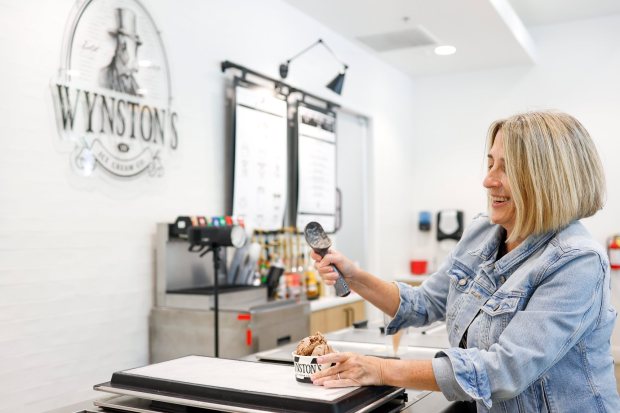 Sarah Wynn, co-owner of Wynston's Ice Cream Co., scoops ice cream for a customer on Thursday, July 16, 2026 in San Marcos. (Meg McLaughlin / The San Diego Union-Tribune)