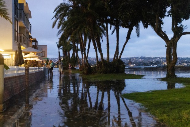 Water floods Mission Beach's Bayside Walk during a king tide event on Monday, July 13, 2026, in San Diego, CA. (Luke Johnson / The San Diego Union-Tribune)