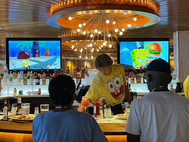 A bartender serves drinks while "Spongebob Squarepants" plays in the background at Comic-Con. (Serena Neumeyer / The San Diego Union-Tribune)
