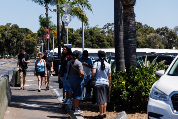 Visitors walk through the parking lot of the San Diego Zoo in San Diego on Thursday, July 23, 2026. (Kristian Carreon / The San Diego Union-Tribune)