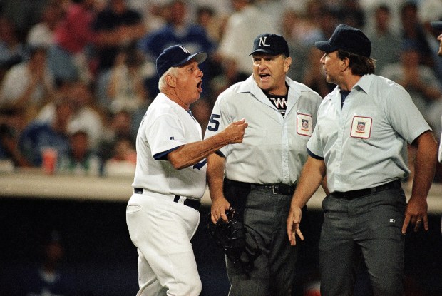 Dodgers manager Tommy Lasorda, left, argues with umpires Jim Quick, center, and Bob Davidson after Quick ejected Lasorda during the ninth inning against the St. Louis Cardinals on Aug. 10, 1995. The Dodgers lost by way of forfeit during the ninth inning after fans repeatedly threw baseballs onto the field. The Cardinals won the game 2-1. (AP Photo/Michael Caulfield)