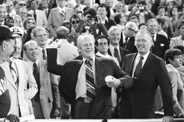In this July 13, 1976, file photo, President Gerald Ford throws the ceremonial first pitch to start the Baseball All-Star game in Philadelphia. At right is Baseball Commissioner Bowie Kuhn. (AP Photo)