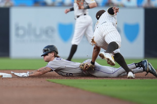 Colorado Rockies' Cole Carrigg, left, is tagged out by San Diego Padres shortstop Xander Bogaerts, caught trying to steal second base during the first inning of a baseball game Tuesday, July 28, 2026, in San Diego. (AP Photo/Gregory Bull)