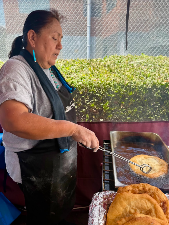 a woman works at her fry bread stand.