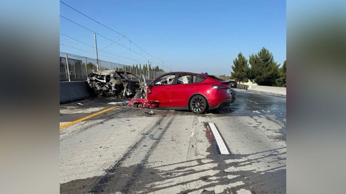 A red Tesla and multiple burned vehicles sit on Highway 87 after a fatal crash in San Jose, California.