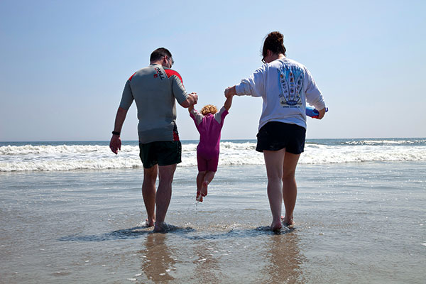 A family frolics by the ocean in Stone Harbor.