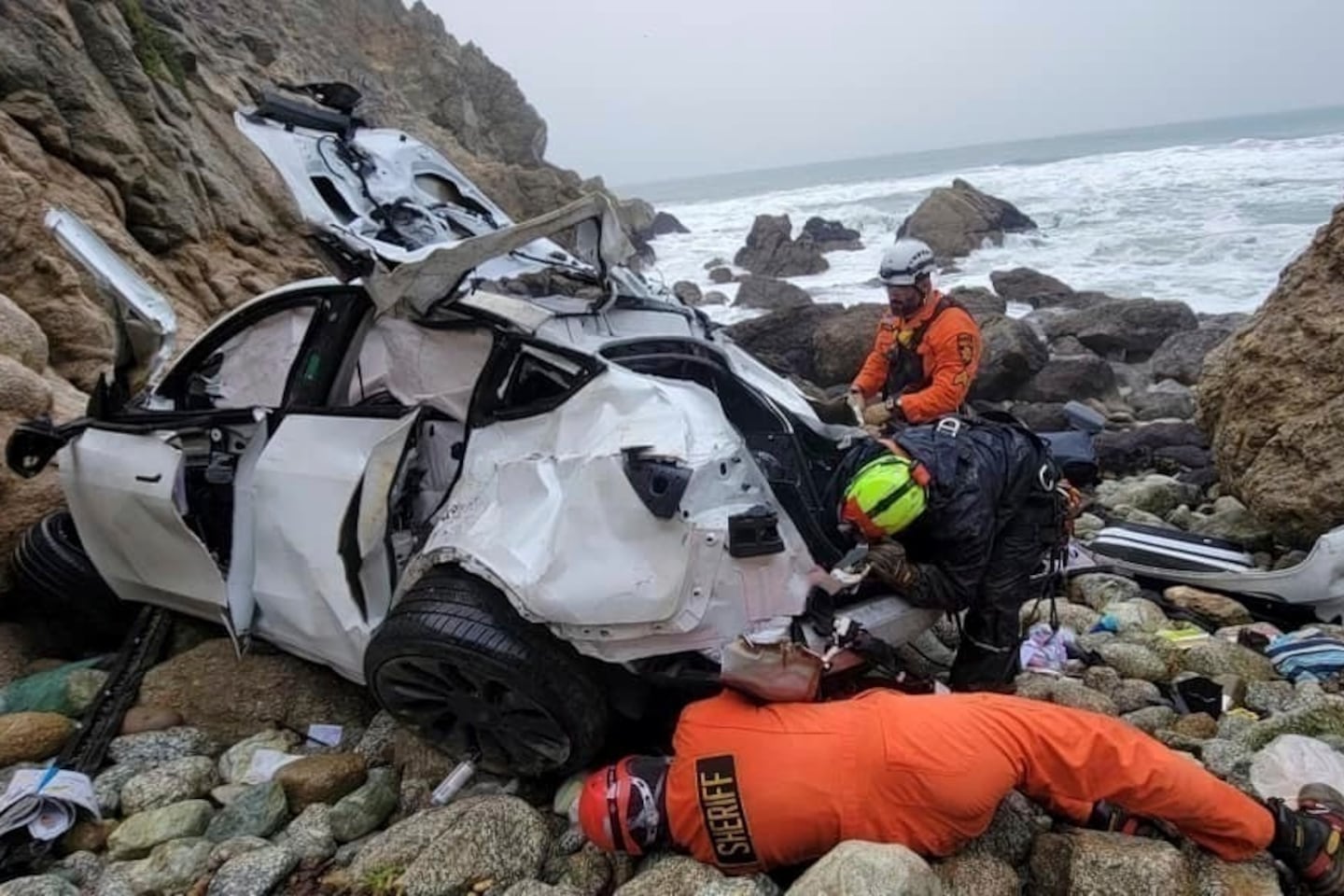 Emergency personnel respond to a vehicle over the side of Highway 1 on Jan. 1, 2023, in San Mateo County, Calif.