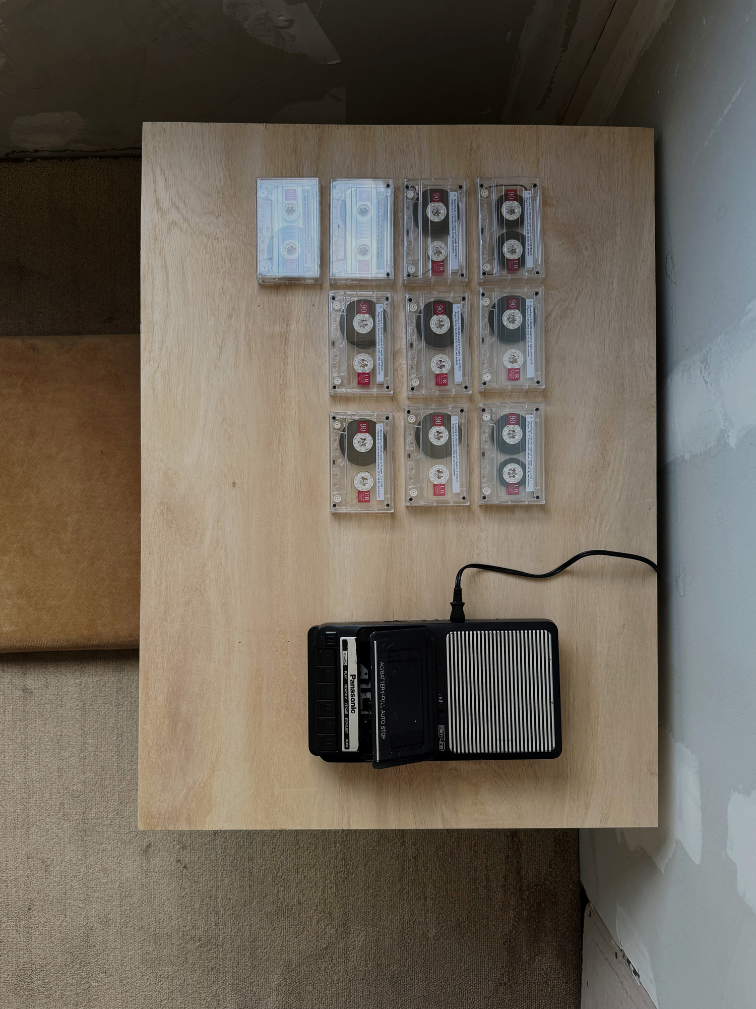 overhead view of tape player and nine cassettes