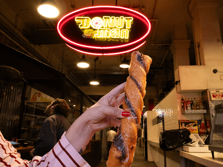 a woman holding a tiger tail donut