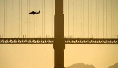 A helicopter flies past the Golden Gate Bridge while searching for missing victims after a boat accident near Alcatraz Island off San Francisco.