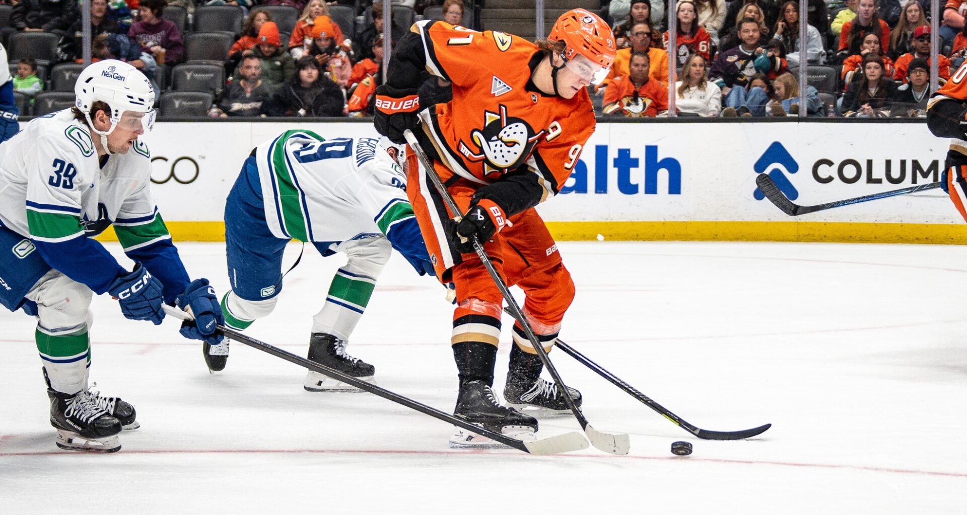 Apr 12, 2026; Anaheim, California, USA; Anaheim Ducks center Leo Carlsson (91) skates with the puck against Vancouver Canucks center Ty Mueller (39) during the second period at Honda Center.