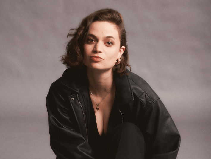 a woman in all black poses on the ground
