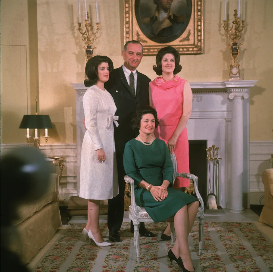 American president Lyndon Baines Johnson (1908-1973) poses with his daughters Luci Baines Johnson (R), Lynda Bird Johnson (L), and his wife Lady Bird Johnson (seated) in front of a fireplace at the White House, Washington, DC, circa 1966.