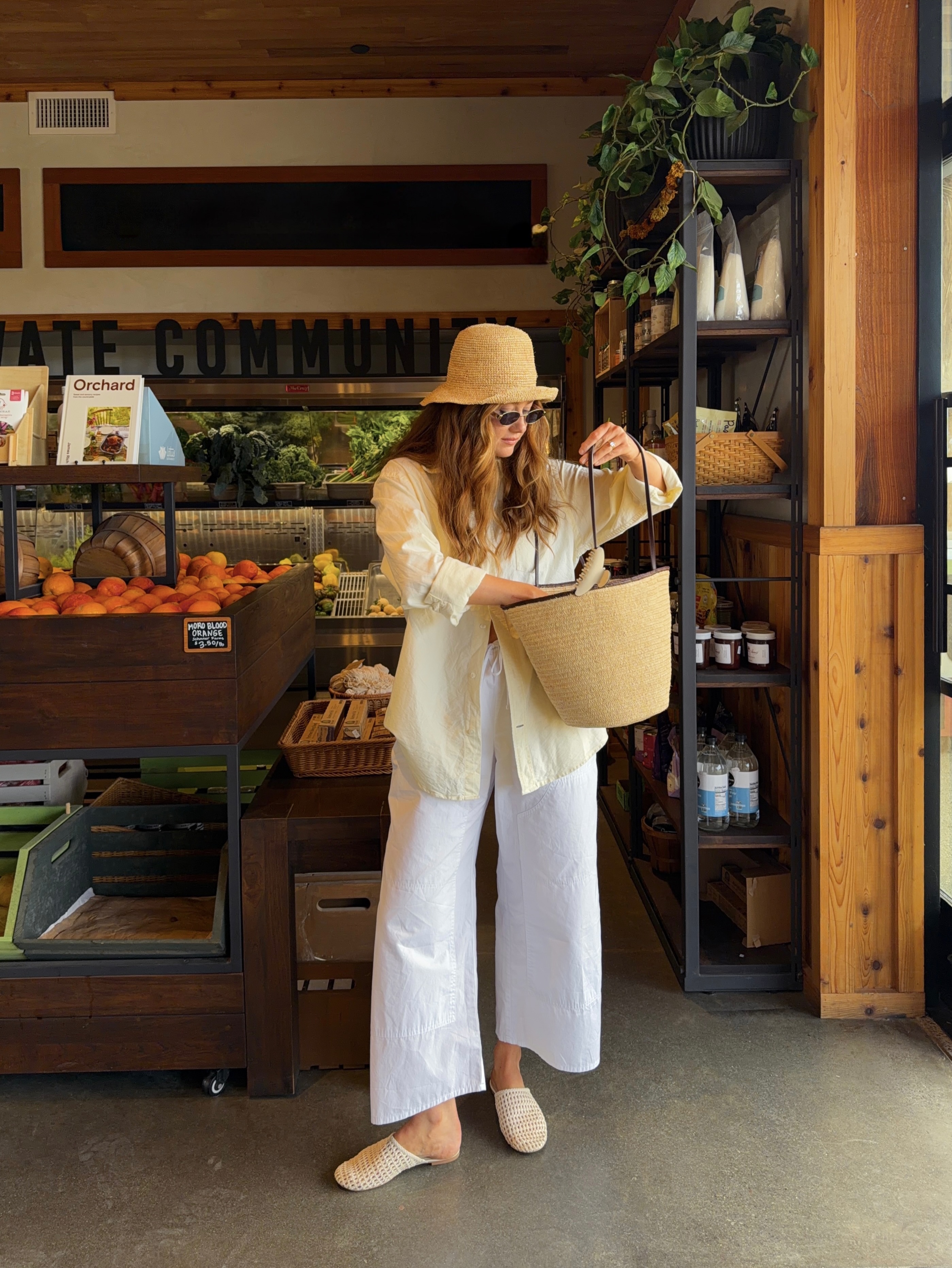 Allison in sun hat, white trousers and basket bag