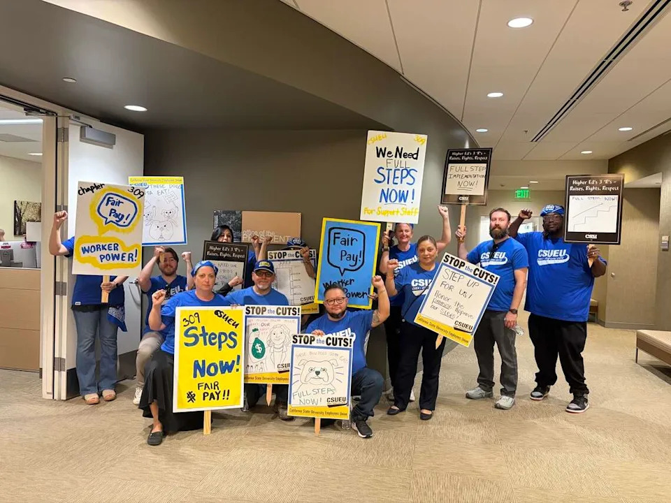 The Fresno State chapter of the CSU Employees Union poses outside of the university president’s office after dropping off a letter.