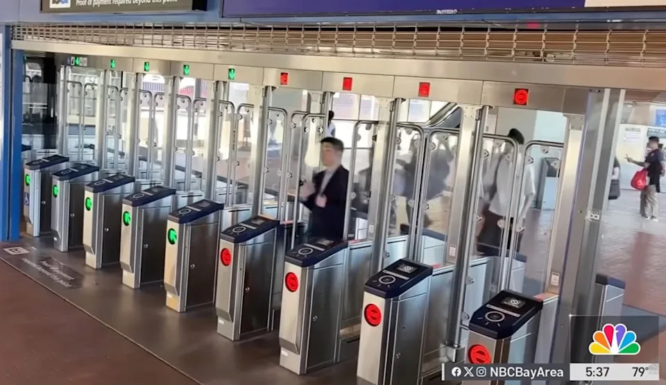 A woman trying to dodge the fare at a San Francisco BART station ended up trapped beneath one of the transit system's new fare gates in a bizarre scene caught on video that has since gone viral. NBC Bay Area