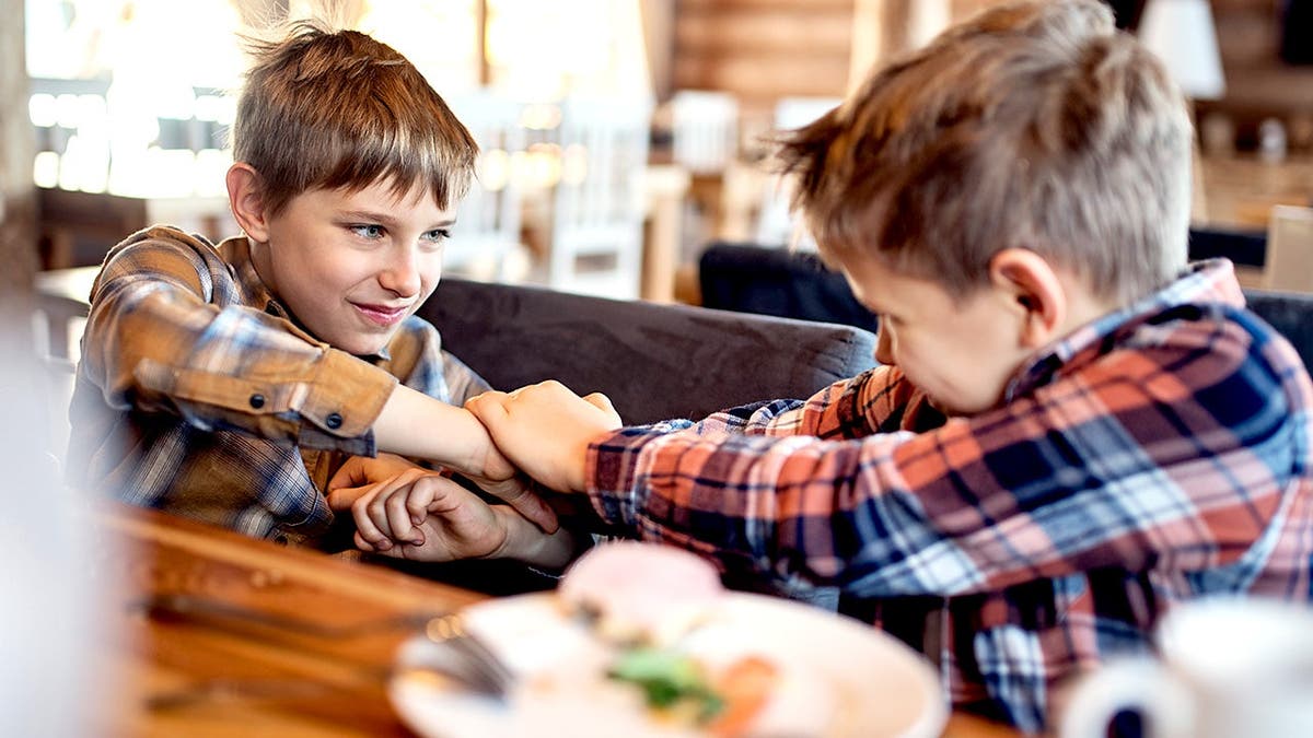Two young boys argue inside a restaurant in stock photo.