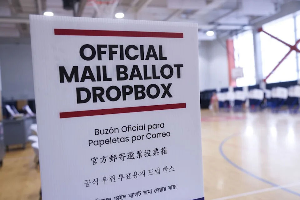 An “OFFICIAL MAIL BALLOT DROPBOX” sign in multiple languages at a voting poll. Michael Nagle